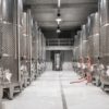 Stainless steel fermentation tanks aligned in a clean brewery facility featuring advanced brewery refrigeration systems.