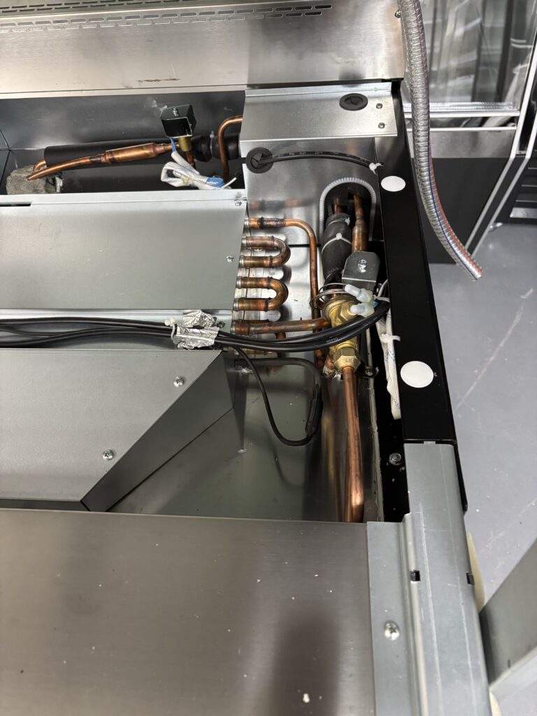 Inside the First Select FRDM deli meat case: copper piping, insulated refrigerant lines and valves